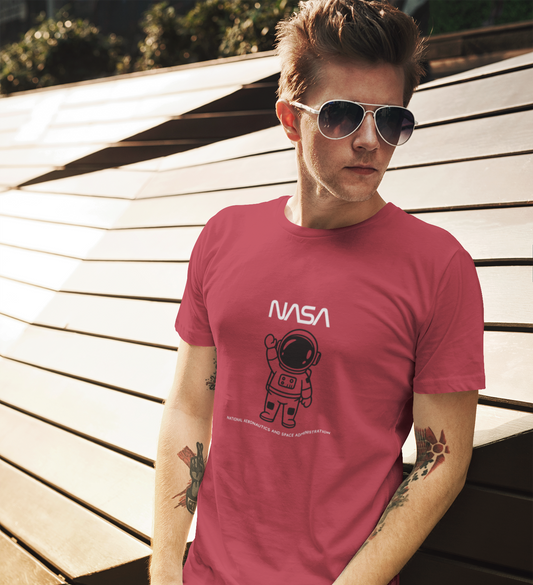 Man wearing a red t-shirt with NASA logo and astronaut graphic outdoors.
