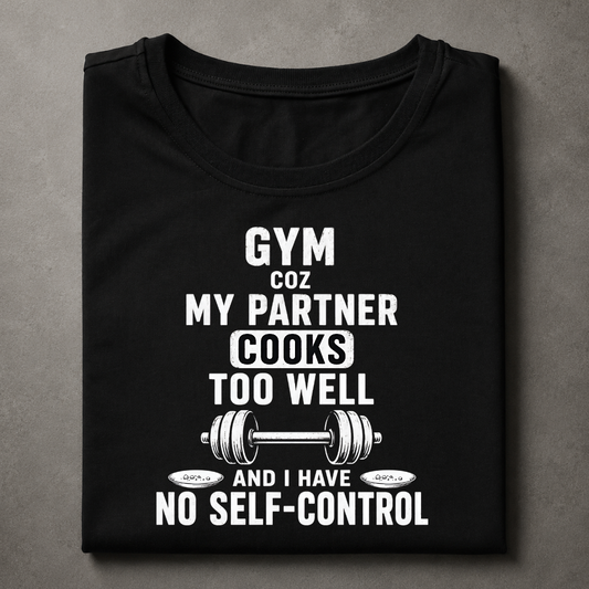 A black short-sleeve t-shirt with a humorous white graphic print that reads 'GYM COZ MY PARTNER COOKS TOO WELL AND I HAVE NO SELF-CONTROL' accompanied by a barbell illustration, displayed flat on a textured gray background.
