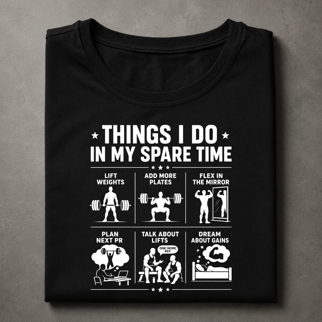 A black short-sleeve t-shirt with a white graphic print on the front, laid flat on a textured gray background. The graphic features the text 'THINGS I DO IN MY SPARE TIME' above six white fitness-themed illustrations and captions.