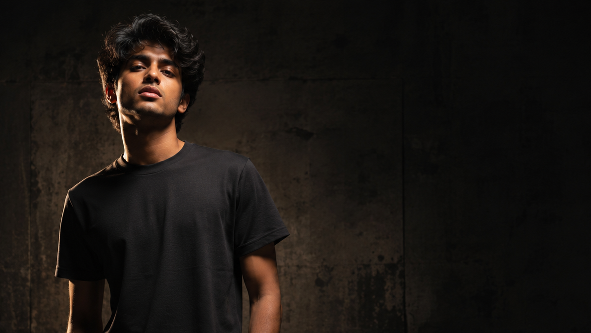 Person wearing a black t-shirt against a dark background
