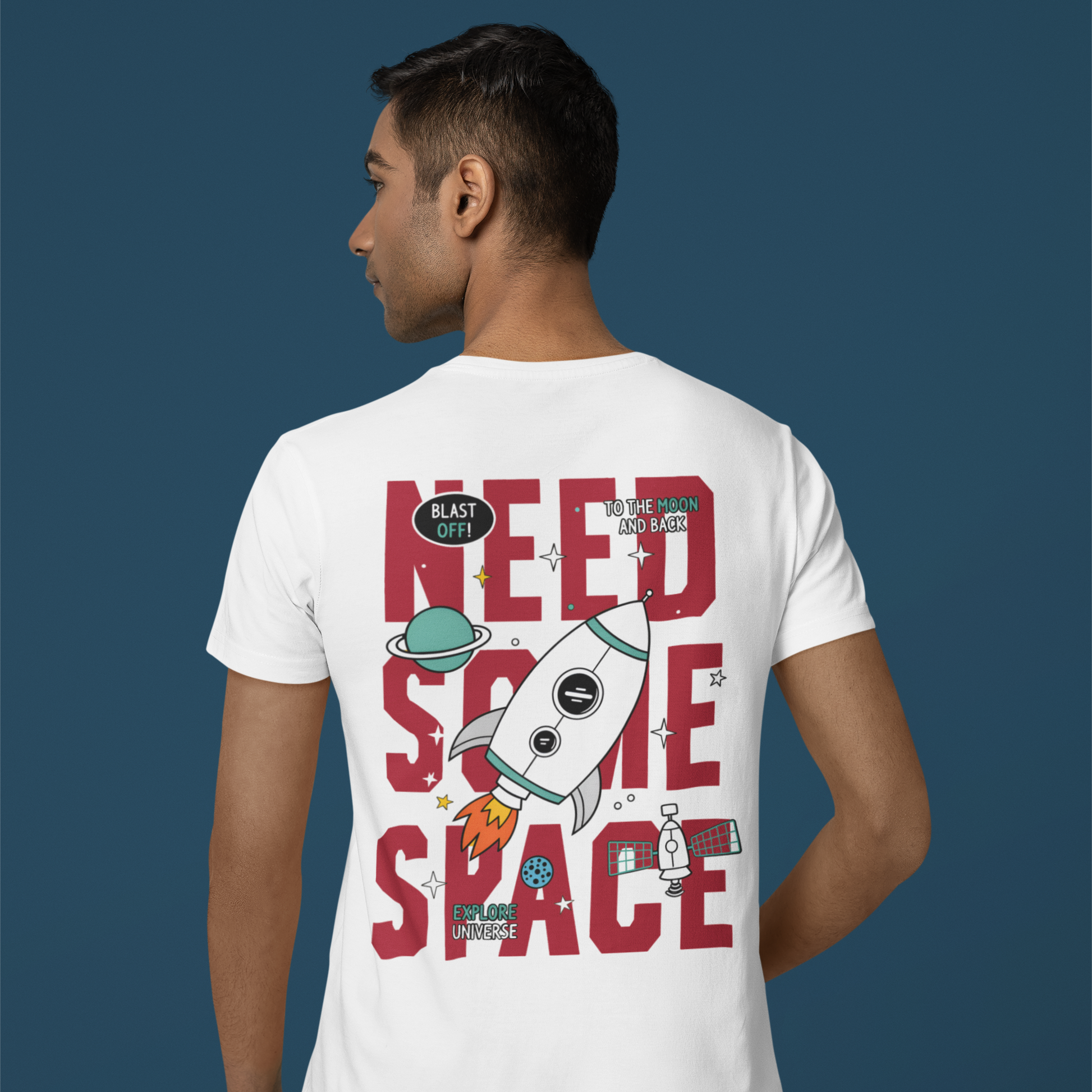 Person wearing a white t-shirt with a space-themed design on the back against a blue background